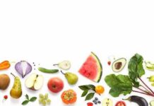 One Fruit Slashes Your Blood Sugar Load Assorted fresh fruits and vegetables arranged along the bottom on white