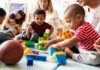 Bilingual Toddlers Stun Scientists Karyn Polito with toddlers building blocks on a play mat