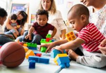 Bilingual Toddlers Stun Scientists Karyn Polito with toddlers building blocks on a play mat