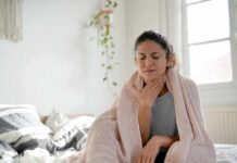 Woman wrapped in blanket touching her throat