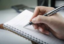 Adult ADHD and Perfectionism: The Surprising Link A hand holding a pen above a blank notebook page