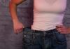 Losing Weight Too Quickly Comes With A Cost person in white tank top showing loose jeans waistband