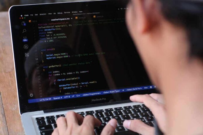 person typing on a laptop with code editor open
