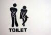 toilet sign with two figures crossing legs