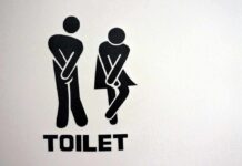 toilet sign with two figures crossing legs