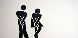 toilet sign with two figures crossing legs