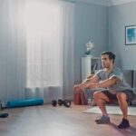 Man doing bodyweight squats in a living room