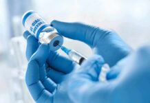 What Fauci Knew About COVID Vaccine Effects on Miscarriages Gloved hands drawing vaccine from vial with syringe