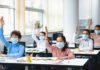 CDC Sounds Alarm: Measles Roars Back Schoolchildren wearing masks raise hands in a classroom
