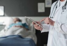 Heart Inflammation Surge Stuns Doctors Doctor using tablet beside hospital patient