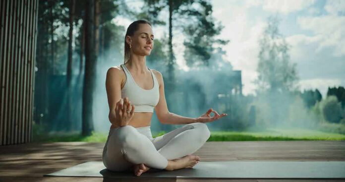 Woman meditating outdoors in a seated yoga pose
