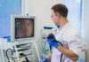 Young Bodies, Deadly Cancer Trend Doctor holding endoscope beside monitor during procedure