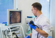 Young Bodies, Deadly Cancer Trend Doctor holding endoscope beside monitor during procedure