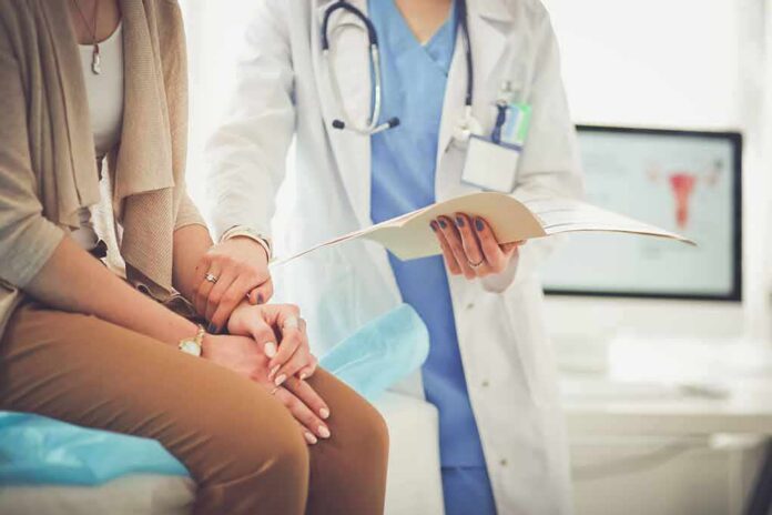 Doctor comforting patient while reviewing medical chart