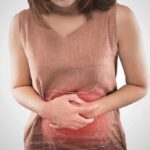 woman holding her stomach in pain with digestive graphic overlay