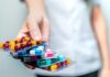 Effects of Pill Stacking on Brain Health Hand holding blister packs of assorted capsules