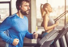 How To Hack Your Brain To Enjoy Workouts Man in blue long-sleeve running on a treadmill with headphones