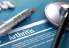 Knee Relief Breakthrough – No Drugs Needed Syringe and stethoscope on arthritis document