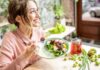 Woman eating a fresh salad at a cafe table
