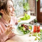Woman eating a fresh salad at a cafe table