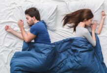 Scary Sleep Metric Tied To Dementia Couple sleeping back to back under a blue blanket