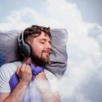 Man sleeping with headphones on a pillow