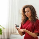 Woman using a blood glucose meter at home