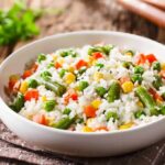 Vegetable rice in a white bowl on a rustic table