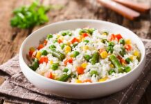 Vegetable rice in a white bowl on a rustic table