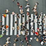 Crowd of pedestrians crossing a zebra crosswalk from above