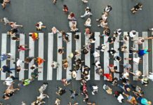 Crowd of pedestrians crossing a zebra crosswalk from above