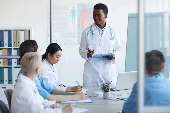 shutterstock_1674031663 Doctor leading a meeting with medical team in a conference room