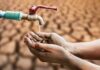 Hands catching drops from a faucet over parched ground