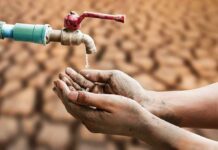 Hands catching drops from a faucet over parched ground