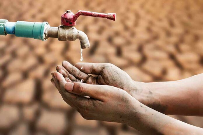 shutterstock_1680600826 Hands catching drops from a faucet over parched ground