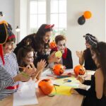 children in Halloween costumes doing crafts at a table