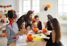 children in Halloween costumes doing crafts at a table