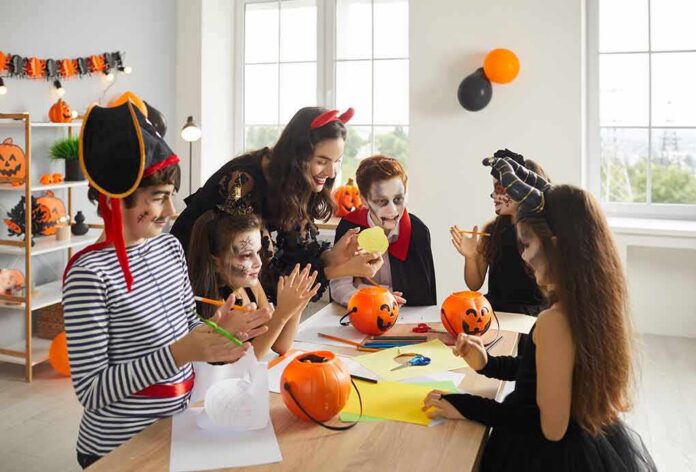 children in Halloween costumes doing crafts at a table