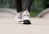 Close-up of person walking in gray sneakers