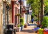 Charming small-town street with colorful storefronts and flowers