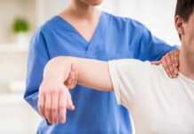 Physical therapist guiding a patient's arm during shoulder exercise