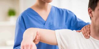 Physical therapist guiding a patient's arm during shoulder exercise