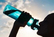 Overhydration Warning – Deadly Gym Mistake Silhouette person drinking from a blue water bottle
